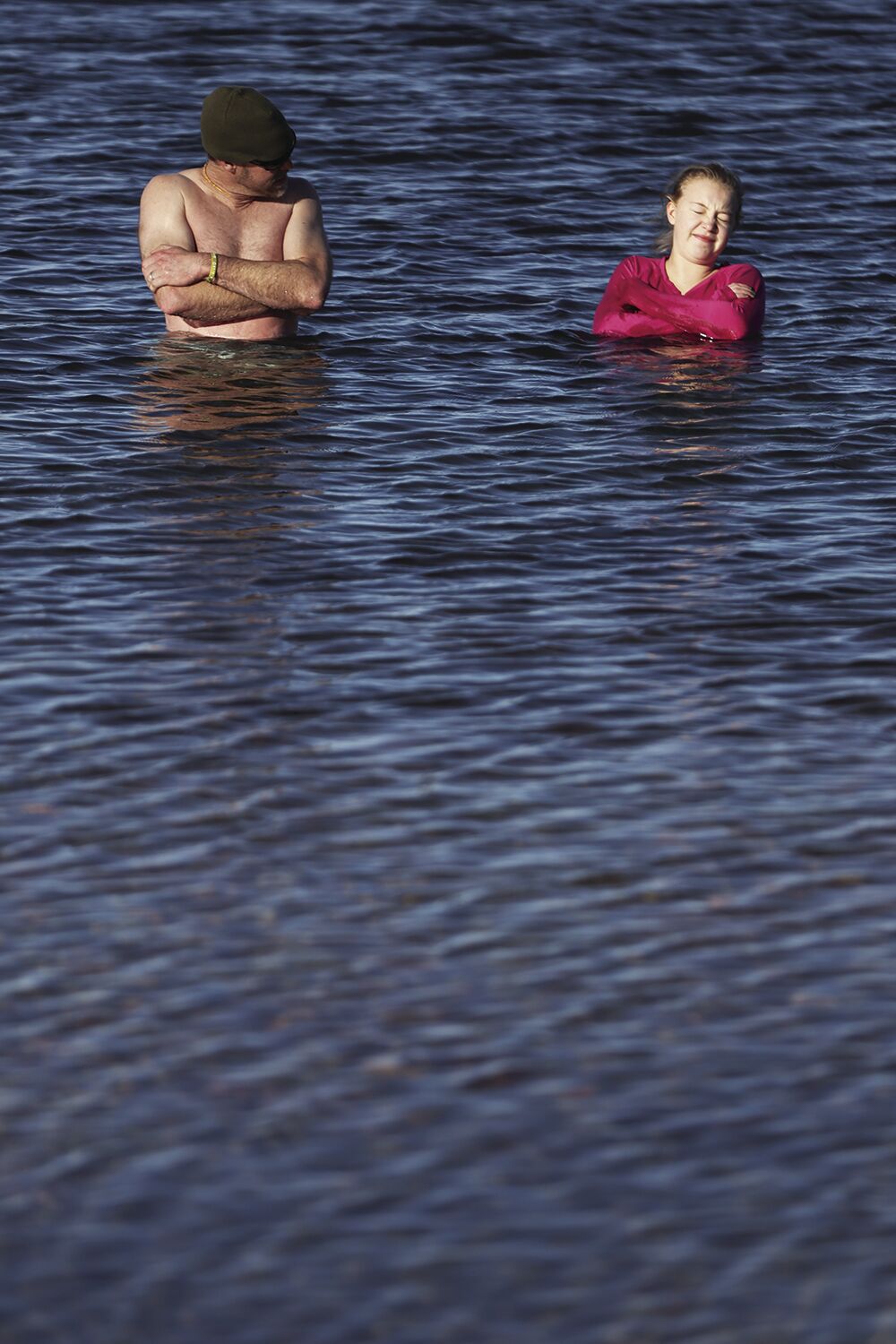 Derek Andrews and his daughter Molly, 15, shiver in Lake DeSmet